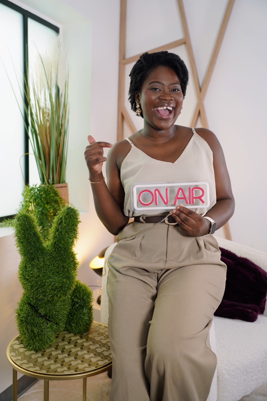 Néty Behoundja tenant un panneau On Air